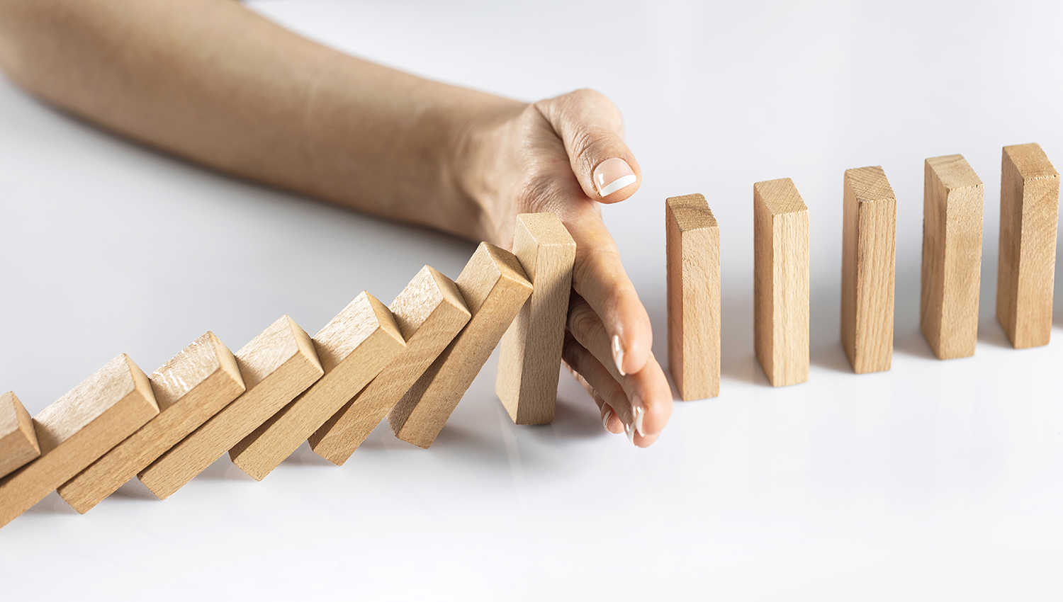 Hånd stopper dominobrikker